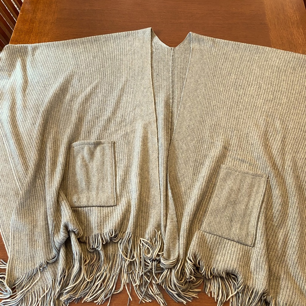 This is a poncho sweater. No brand name. Never worn. Taupe. Gray. Cream. Fringes